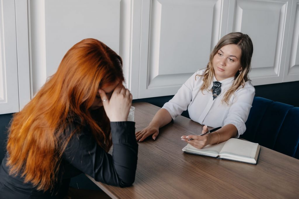 ผู้หญิงสองคนมีการสนทนาทางอารมณ์ที่โต๊ะ