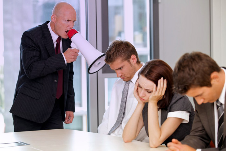 ผู้ชายตะโกนใส่กลุ่มผ่านโทรโข่ง