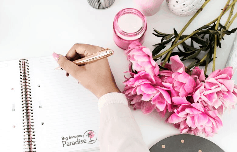 笔记本、粉色牡丹、手和一支金笔