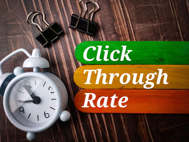 คลิปหนีบกระดาษรูปด้านบนและแท่งไม้สีพร้อมข้อความคลิกผ่านอัตราการคลิกบนพื้นไม้