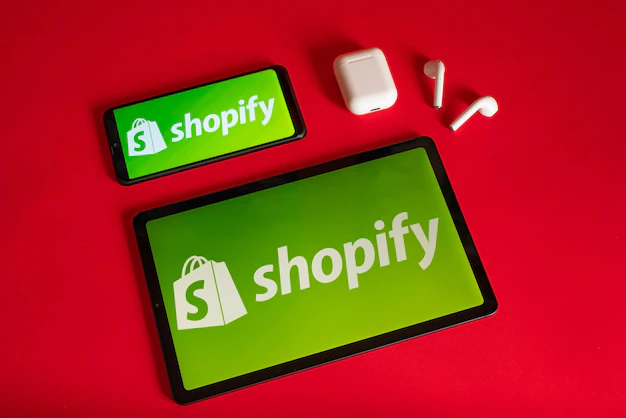 Foto tokio japan 05. juni 2022 shopify-webseite angezeigt auf einem modernen laptop-smartphone und notebook auf rotem hintergrund shopify-logo auf dem iphone
