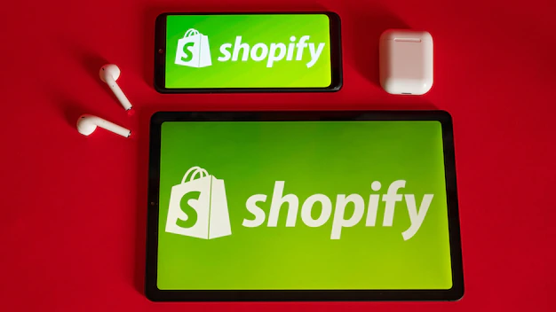 Foto tokio japan 05. juni 2022 shopify-webseite angezeigt auf einem modernen laptop-smartphone und notebook auf rotem hintergrund shopify-logo auf dem iphone