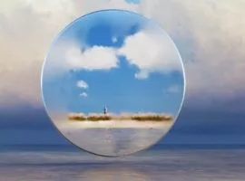 Immagine di una persona attraverso l'obiettivo di un telescopio su una spiaggia lontana, che rappresenta i problemi dell'inflazione e della catena di approvvigionamento che interessano tutte le parti del mondo.