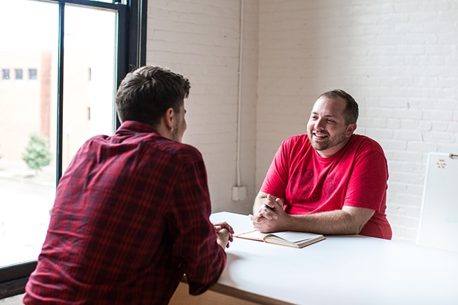 tata letak oleh pekerja lepas roda gila pro dan kontra dua pria berbicara di meja putih