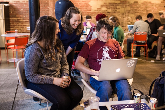 tata letak oleh pekerja lepas flywheel pro dan kontra tiga orang berbicara di sekitar kursi dengan laptop dan kopi