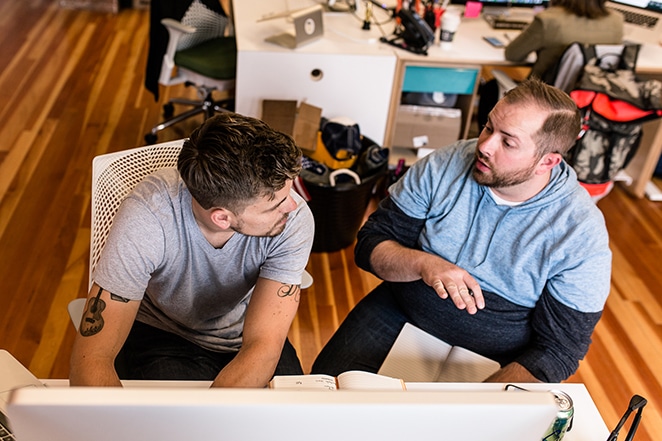 tata letak oleh pekerja lepas roda gila pro dan kontra dua pria berbicara di meja