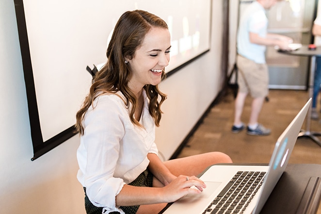 tata letak oleh roda gila menciptakan portofolio desain web yang lebih baik daripada pesaing pria dan wanita yang berdiri di meja tinggi dengan laptop