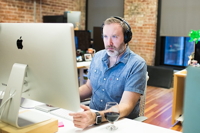 el diseño por las páginas del sitio web del volante ocupa un lugar más alto en la búsqueda del hombre en la computadora con auriculares en las orejas