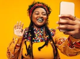 Individu multi-ras, tersenyum di telepon, mewakili penelusuran TikTok menggantikan penelusuran Google untuk Gen Z