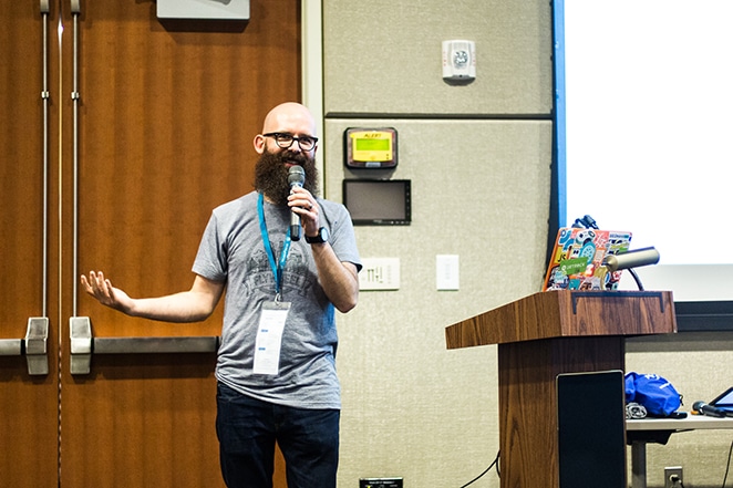 Flywheeler vorbind la conferința din Omaha Nebraska, stând lângă un podium cu un microfon