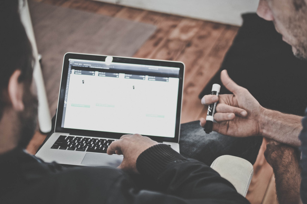 deux hommes collaborent sur un projet devant un écran d'ordinateur portable