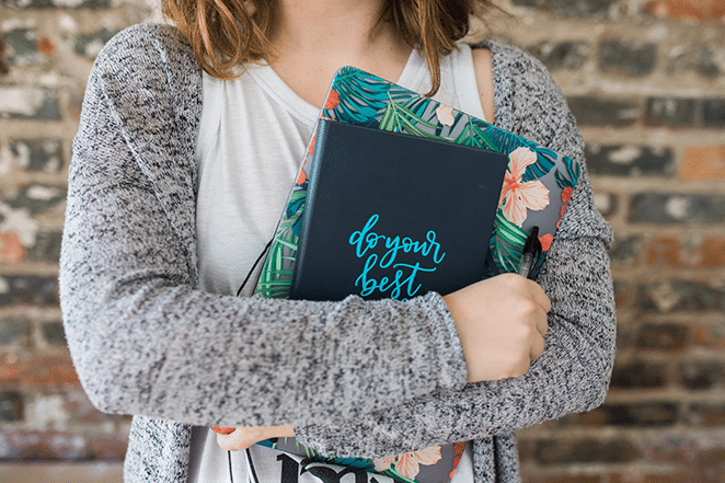 保持している女性はトロピカルカバーであなたの最高の仕事のノートブックとラップトップを行います