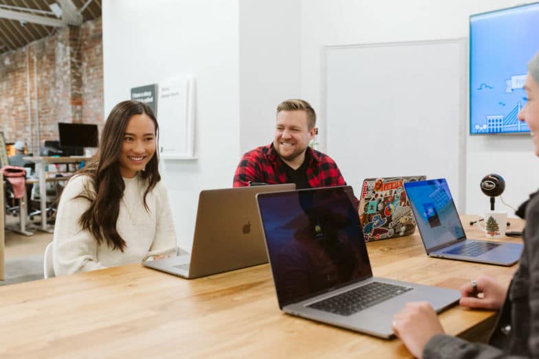 membros da equipe colaboram em um projeto em uma grande mesa