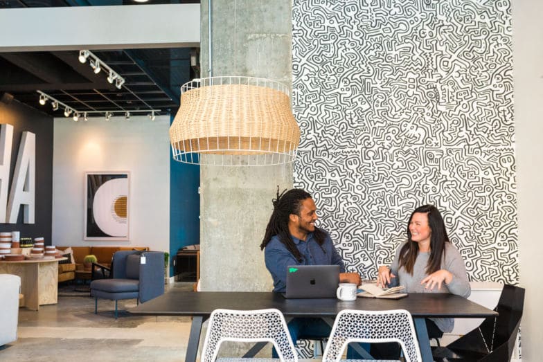 duas pessoas se sentam em uma mesa para discutir um projeto