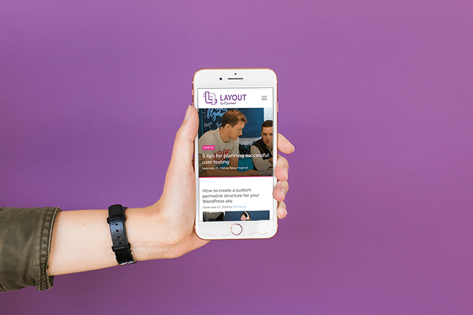 мобильный телефон на фиолетовом фоне, соответствующий бренду через маркетинговые каналы с социальными сетями и блогом с маховиком и макетом