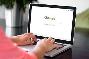 uma mulher em seu computador realizando uma pesquisa de palavras-chave para iniciantes por meio de brainstorming de palavras-chave iniciais