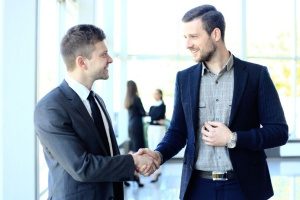 strângere de mână între proprietarul unei agenții de marketing digital și un avocat care va discuta despre un plan strategic de marketing de conținut al unei firme de avocatură